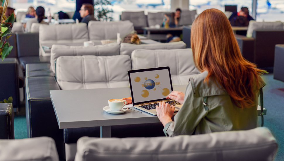 Business traveller working on laptop in airport lounge