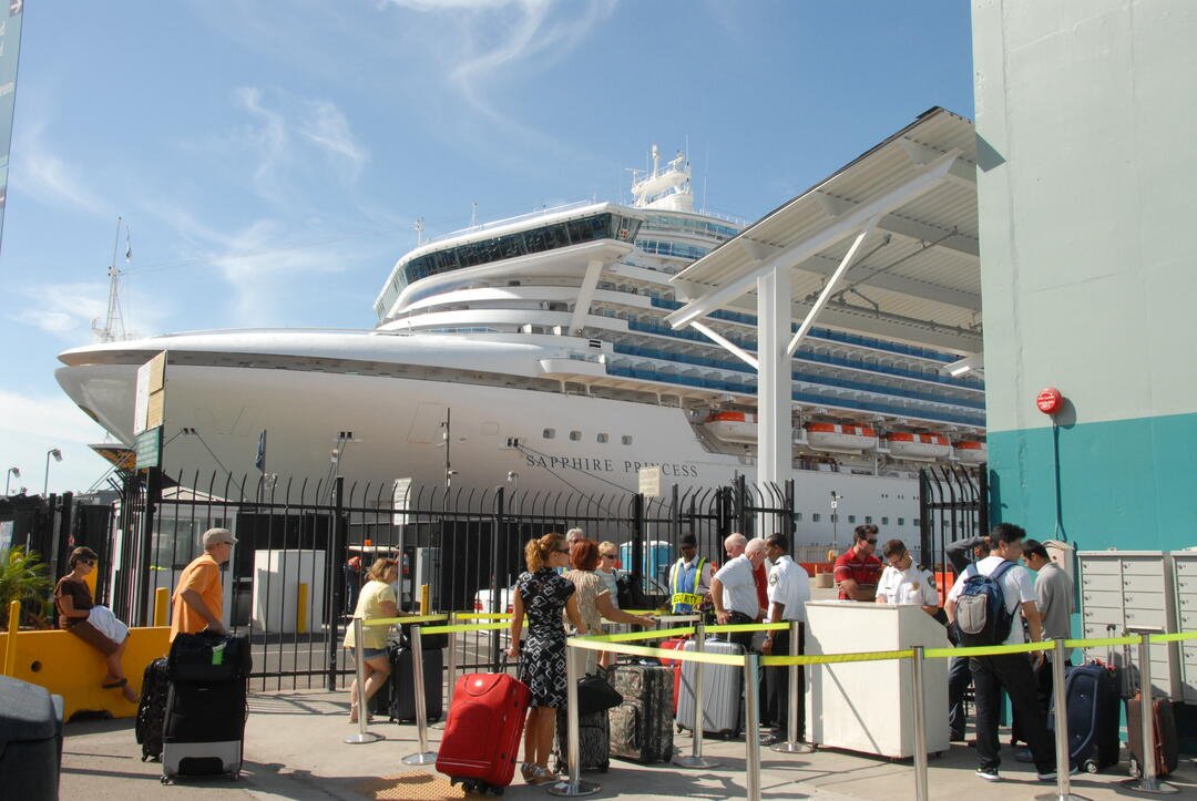 Cruise passengers with luggage boarding at cruise terminal