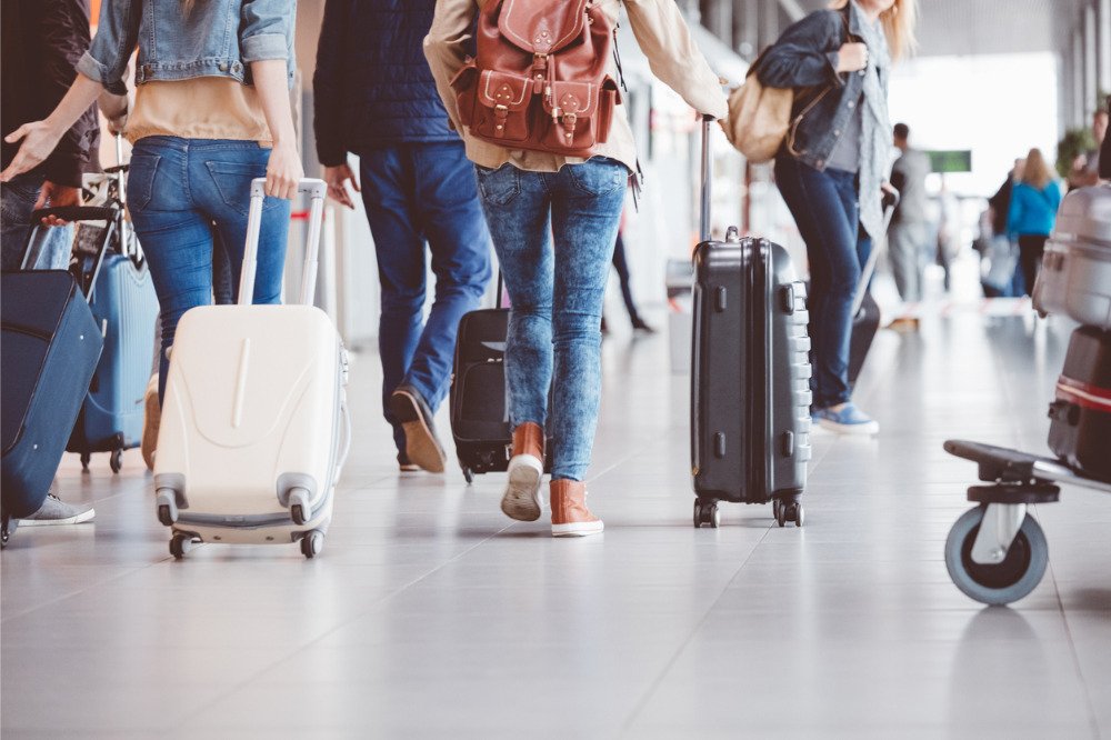 International student arriving in London airport with luggage